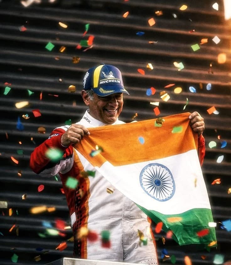 Ajith Kumar on the British F3 racing podium holding the Indian Tricolour flag
